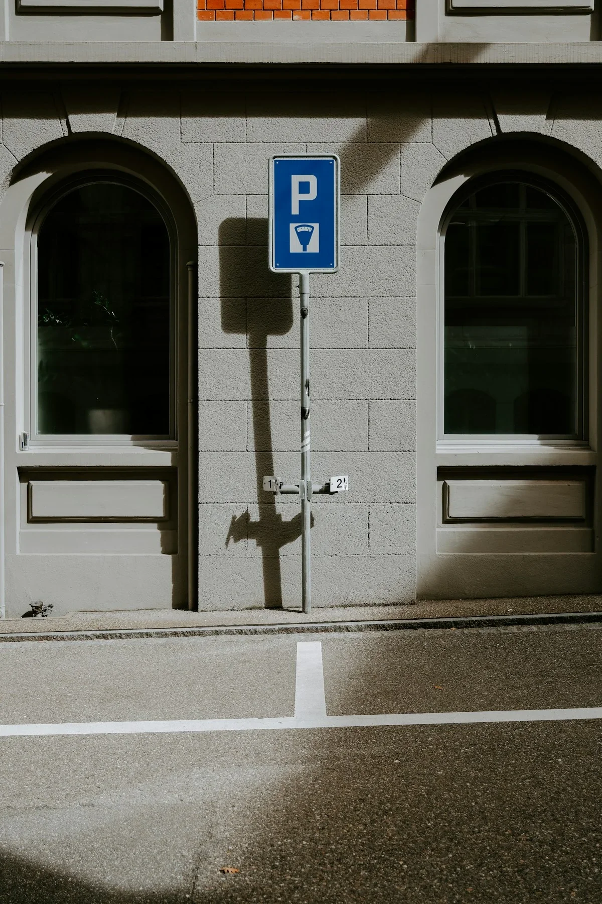 Cars parked along a blue-and-white painted curb on a street in an Israeli city